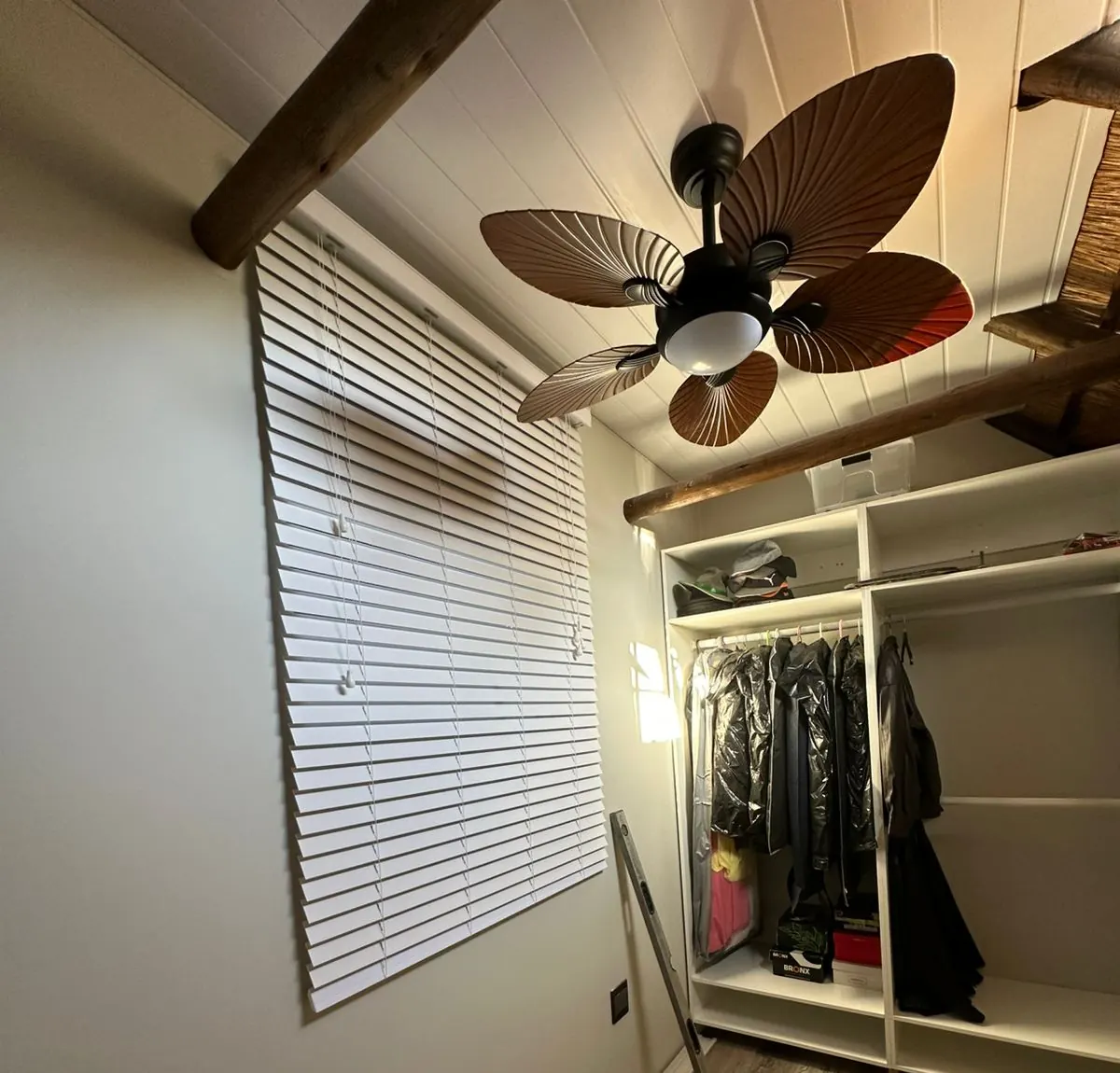 Bedroom with new wooden blinds, ceiling fan and built-in wardrobe