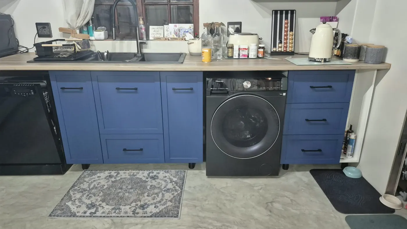 Navy shaker kitchen cabinets with black handles and oak-look worktop