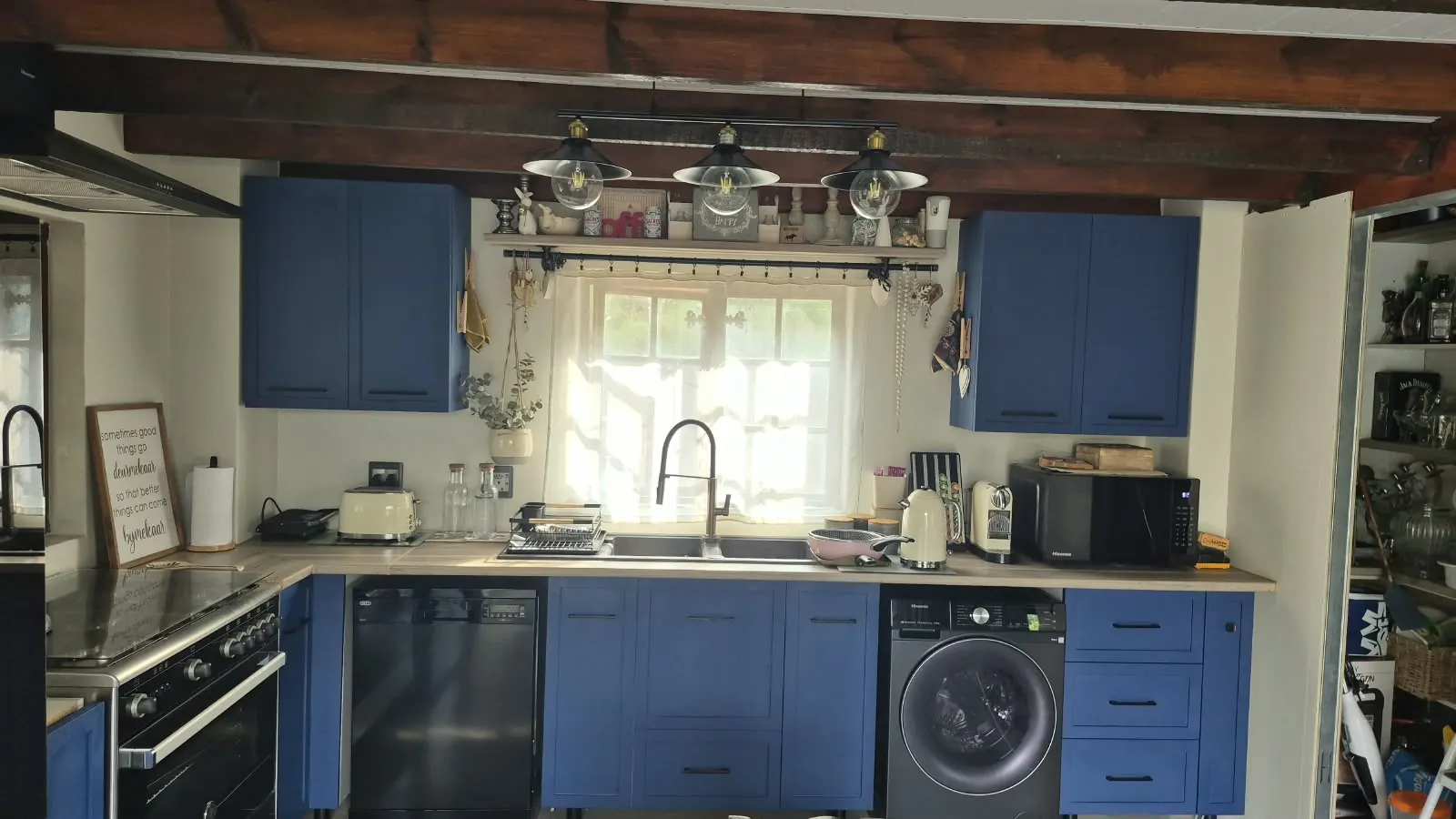 Full kitchen renovation with navy cabinets, exposed beams and pendant lights